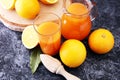 Glass jar of fresh orange juice with fresh fruits on dark table. Royalty Free Stock Photo