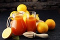 Glass jar of fresh orange juice with fresh fruits on dark table. Royalty Free Stock Photo