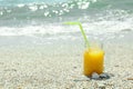 Glass jar of fresh orange juice on seaside, space for text. Summer vacation Royalty Free Stock Photo