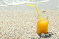 Glass jar of fresh orange juice on seaside, space for text. Summer vacation Royalty Free Stock Photo