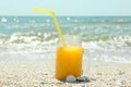 Glass jar of fresh orange juice on seaside, space for text. Summer vacation Royalty Free Stock Photo