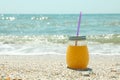 Glass jar of fresh orange juice on seaside, space for text. Summer vacation Royalty Free Stock Photo