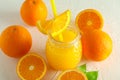 Glass jar with fresh orange juice and tubule, oranges on white background Royalty Free Stock Photo