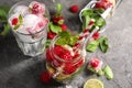 Glass and jar of fresh raspberry mojito on grey table Royalty Free Stock Photo