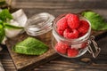 Glass jar with fresh ripe raspberries on wooden table Royalty Free Stock Photo