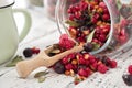 Glass jar of fruit tea with apples, orange, red and black currant berries close up on white kitchen table Royalty Free Stock Photo