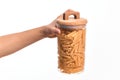 Glass jar full of dry italian penne pasta over isolated background Royalty Free Stock Photo