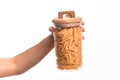 Glass jar full of dry italian penne pasta over isolated background Royalty Free Stock Photo