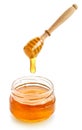 Glass jar full of honey and wooden dipper on white background Royalty Free Stock Photo