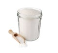Glass jar of granulated sugar and scoop on white background