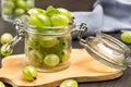 Glass jar with green gooseberries on board Royalty Free Stock Photo