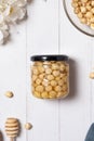 Glass jar with hazelnuts honey and nuts on beige background flat lay. Hazelnuts in honey. Top view Royalty Free Stock Photo