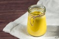 Glass jar with a healthy drink of golden milk from turmeric, milk and pepper on a white linen napkin. Royalty Free Stock Photo