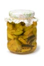 Glass jar with homemade pickled yellow and green zucchini close up on white background