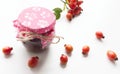 Glass jar of homemade rosehip jam with fresh juicy fruits in the form of ingredients, isolated on white background