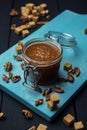 A glass jar of homemade salted caramel and fried walnuts with pieces of cane sugar Royalty Free Stock Photo