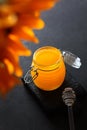 Glass jar with honey on black background. Sunflower flower. Vertical photo. Glass stick for honey. View from above. Bio Royalty Free Stock Photo