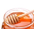 Glass jar of honey with wooden drizzler