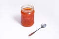 Glass jar of jam on a white background