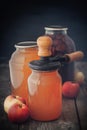 Glass jar of juice, apples and can lid closing machine for canning.
