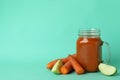 Glass jar of juice and ingredients on mint background