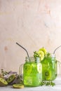 Glass jar of kiwi juice or smoothie. Kiwi Mojito cocktail or non-alcohol mocktail with mint and sliced kiwi fruits on wooden Royalty Free Stock Photo