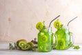 Glass jar of kiwi juice or smoothie. Kiwi Mojito cocktail or non-alcohol mocktail with mint and sliced kiwi fruits on wooden Royalty Free Stock Photo