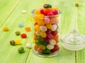 glass jar with lid filled with colorful candies on a wooden green background Royalty Free Stock Photo