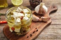 Glass jar of marinated feta cheese on wooden table Royalty Free Stock Photo