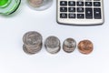 In a glass jar, metal coins, scattered change, a calculator for counting money on a white background, close-up, selective focus.Co Royalty Free Stock Photo