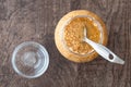 Glass jar of minced garlic and small glass bowl on wood background, with stainless steel tablespoon in jar Royalty Free Stock Photo