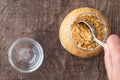 Glass jar of minced garlic and small glass bowl on wood background, womanÃ¢â¬â¢s hand using tablespoon to scoop out garlic Royalty Free Stock Photo