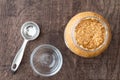 Glass jar of minced garlic, stainless steel tablespoon, and small glass bowl on wood background Royalty Free Stock Photo