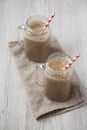 Glass jar mugs filled with coffee, oat and banana smoothie on a white wooden background, low angle view Royalty Free Stock Photo