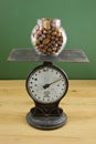 Glass jar of nuts on scale Royalty Free Stock Photo