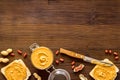 Glass jar of peanut butter with sandwiches and nuts on kitchen table Royalty Free Stock Photo