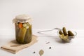 glass jar with pickled cucumbers on white background