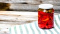 Glass jar with pickled red bell peppers.Preserved food concept, canned vegetables isolated in a rustic composition Royalty Free Stock Photo