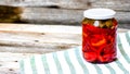 Glass jar with pickled red bell peppers.Preserved food concept, canned vegetables isolated in a rustic composition Royalty Free Stock Photo