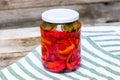 Glass jar with pickled red bell peppers.Preserved food concept, canned vegetables isolated in a rustic composition Royalty Free Stock Photo