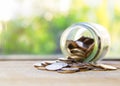 Glass Jar piggy bank with pile of coins on the bokeh background Royalty Free Stock Photo