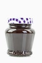 Glass jar of plum jam on white background