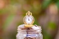 Glass jar with retro clock for time to money saving for retirement concept