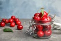 Glass jar with ripe sweet cherries on grey table Royalty Free Stock Photo