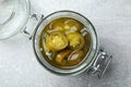 Glass jar with slices of pickled green jalapeno peppers on light grey table, top view Royalty Free Stock Photo