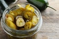 Glass jar with slices of pickled green jalapeno peppers on wooden table, closeup Royalty Free Stock Photo