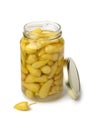 Glass jar with small pickled yellow Turkish hot peppers close up on white background