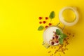 Glass jar of sour cream yogurt with cranberry,  mint and granola on yellow background Royalty Free Stock Photo