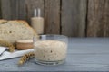 Glass jar with sourdough on grey wooden table. Space for text Royalty Free Stock Photo