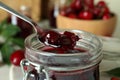 Glass jar and spoon with cherry jam, close Royalty Free Stock Photo